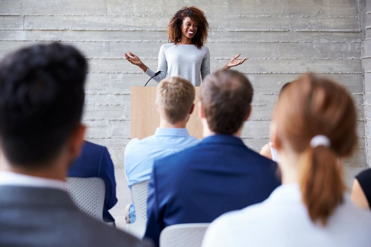 A woman standing in front of a group of people.